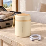 Lunch box électrique chauffante USB-C posée sur une table de chambre d'hôtel en voyage