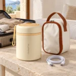Thermos chauffant USB et son sac posés sur une table en voyage
