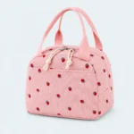 Petit sac isotherme rose à motif fraises, avec deux anses, zip à deux curseurs et poche avant