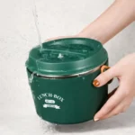 Lunch box chauffante verte rincée sous l’eau, couvercle fermé